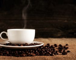 Bitterstoffe in Lebensmitteln: Kaffeetasse mit Kaffeebohnen und Dampf